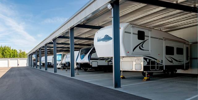 A commercial covered RV storage facility with multiple recreational vehicles parked under a large RV carport