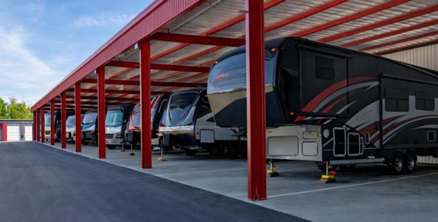 RVs parked under a red steel carport structure for covered storage