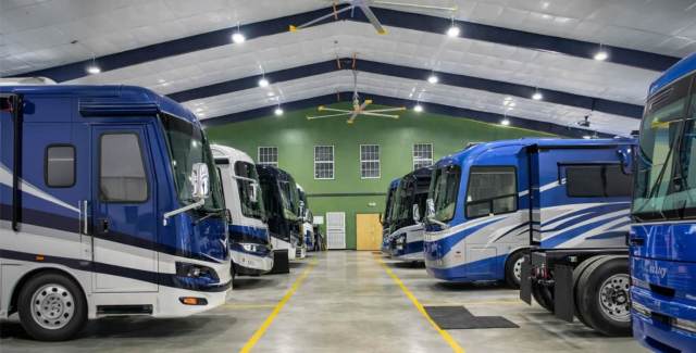 Indoor RV storage facility with motorhomes parked in organized rows