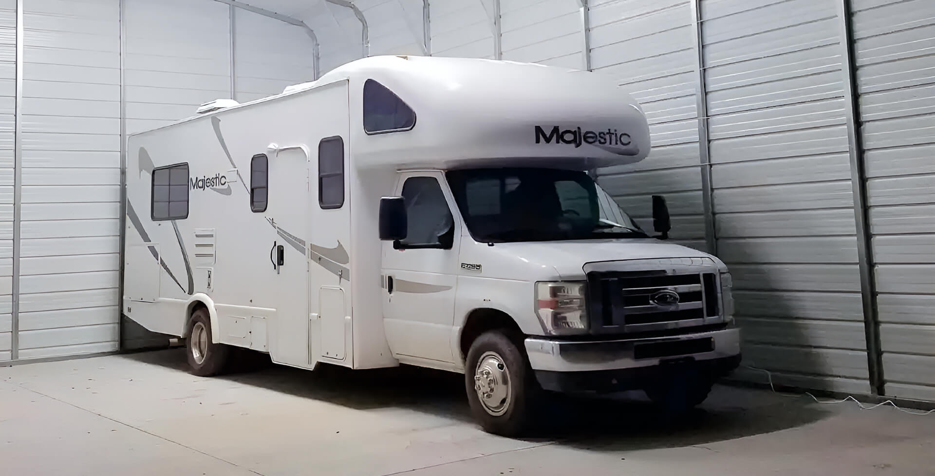 Large RV garage with a white recreational vehicle inside
