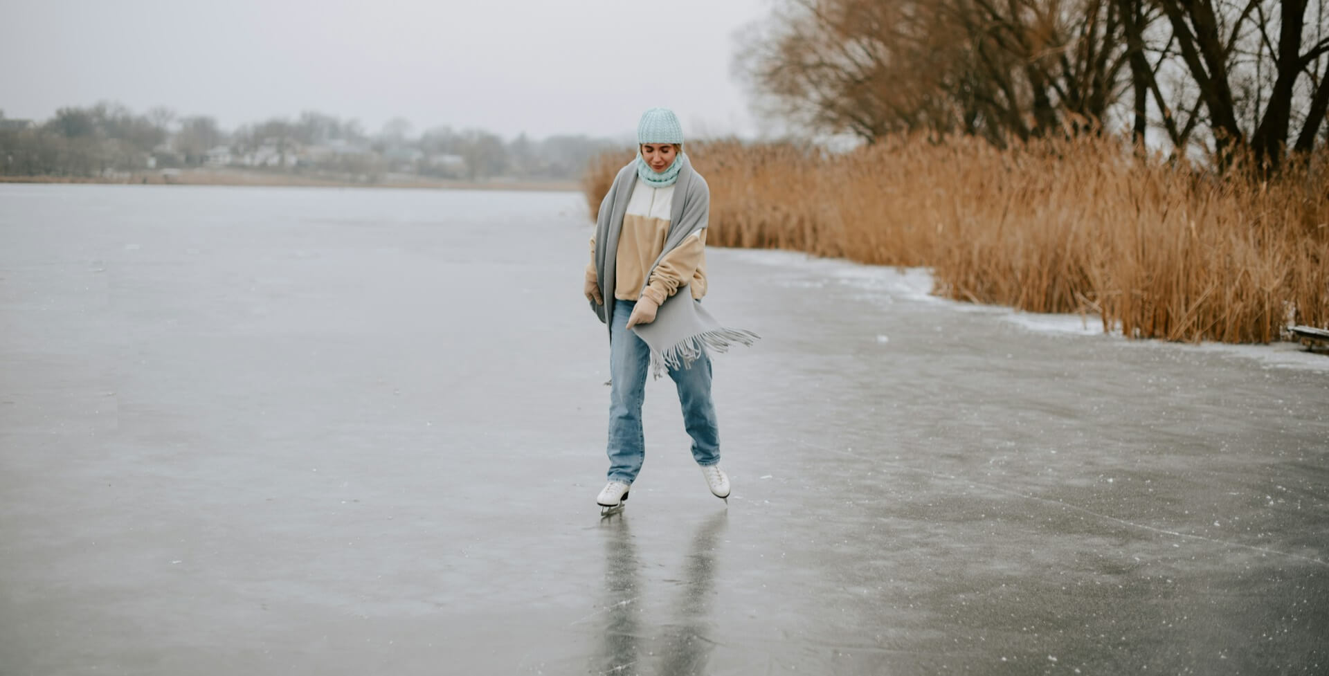 Person ice skating on a frozen lake during winter