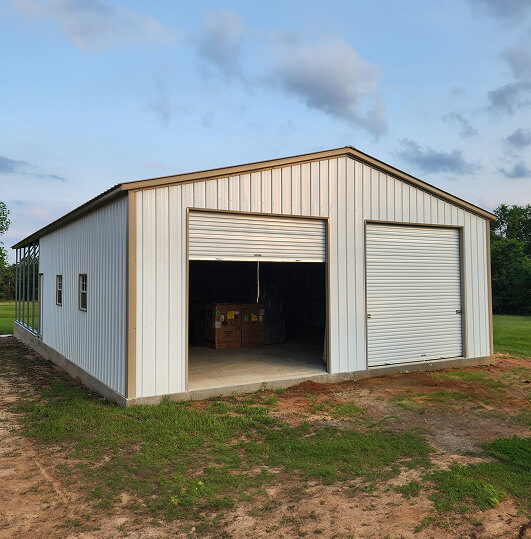 Metal building with one closed garage door and one open garage door