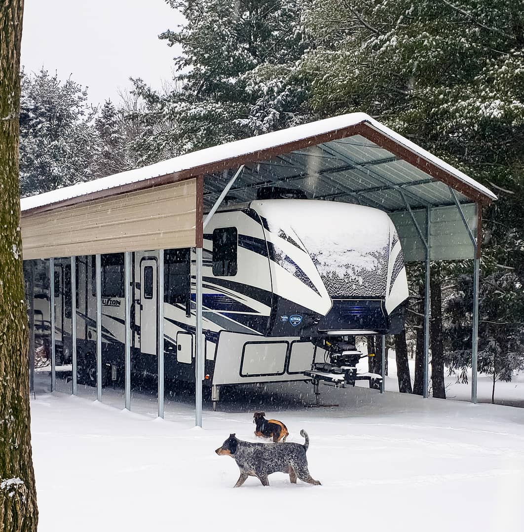 RV inside of a carport in snow