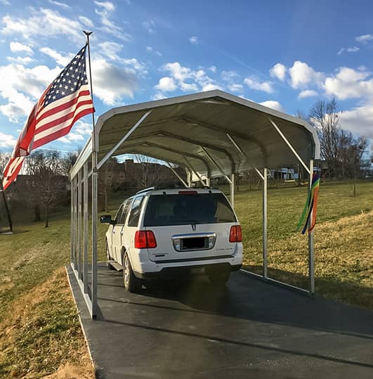 Carport with a car inside and an American flag on the side