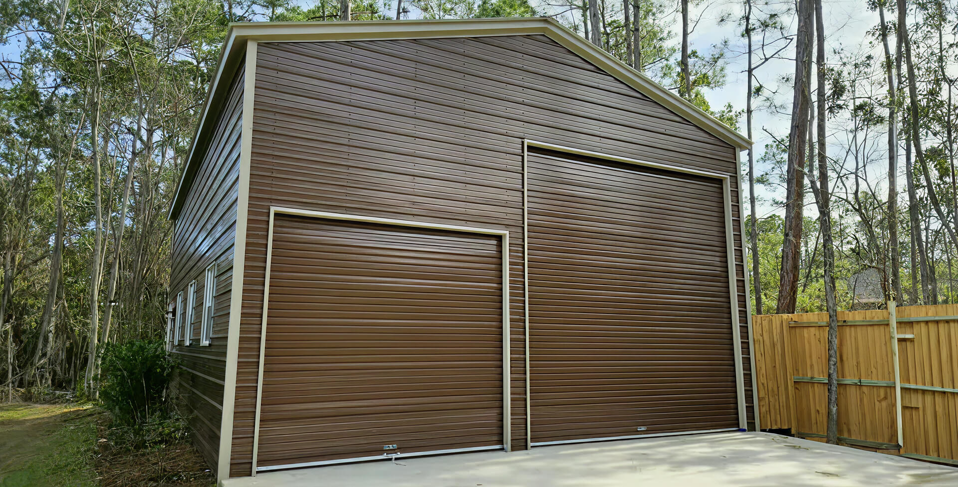 Large brown wood-sided garage building with two bay doors