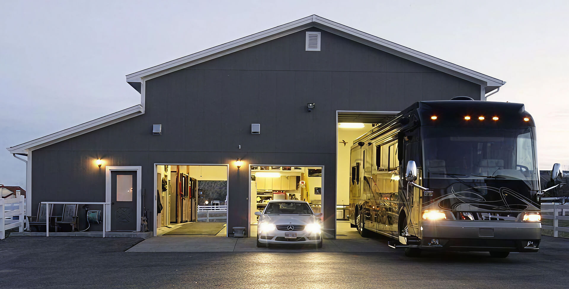 Modern gray garage with car and black RV inside
