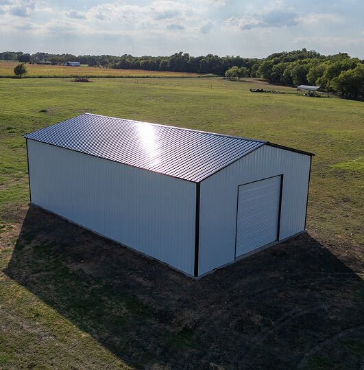 Large white metal building with black roof