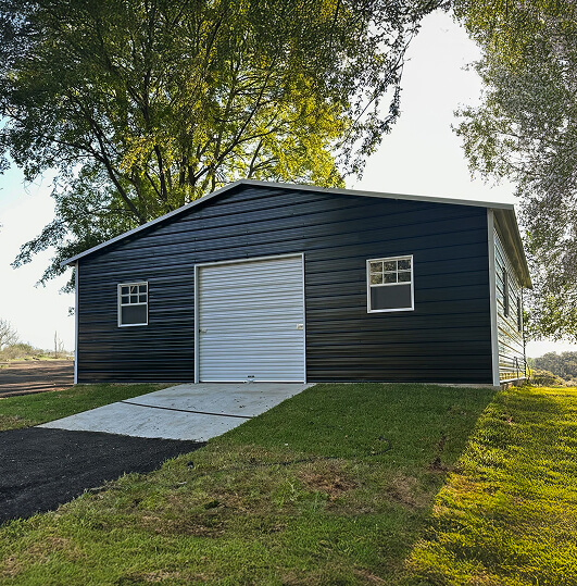 Metal building with a garage door and two windows