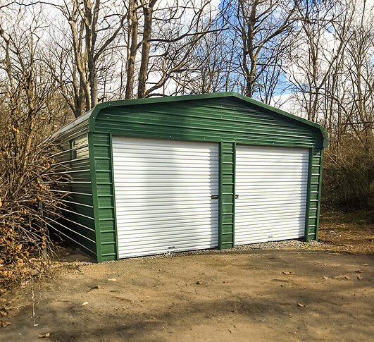 Green metal building with two garage doors