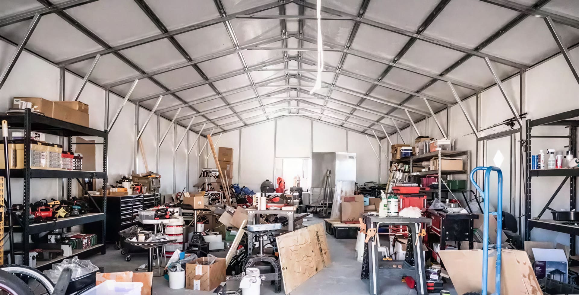 Inside view of a detached metal garage converted into a workshop and storage area.