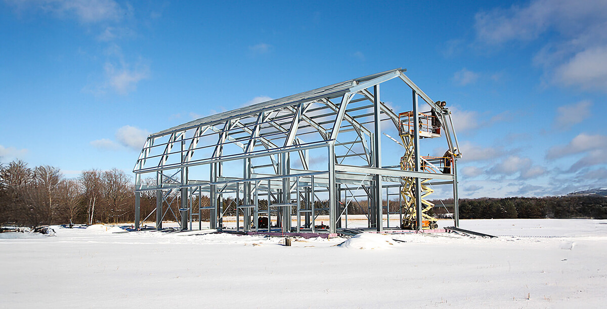 Steel-frame building under construction, showing exposed metal beams and framing.