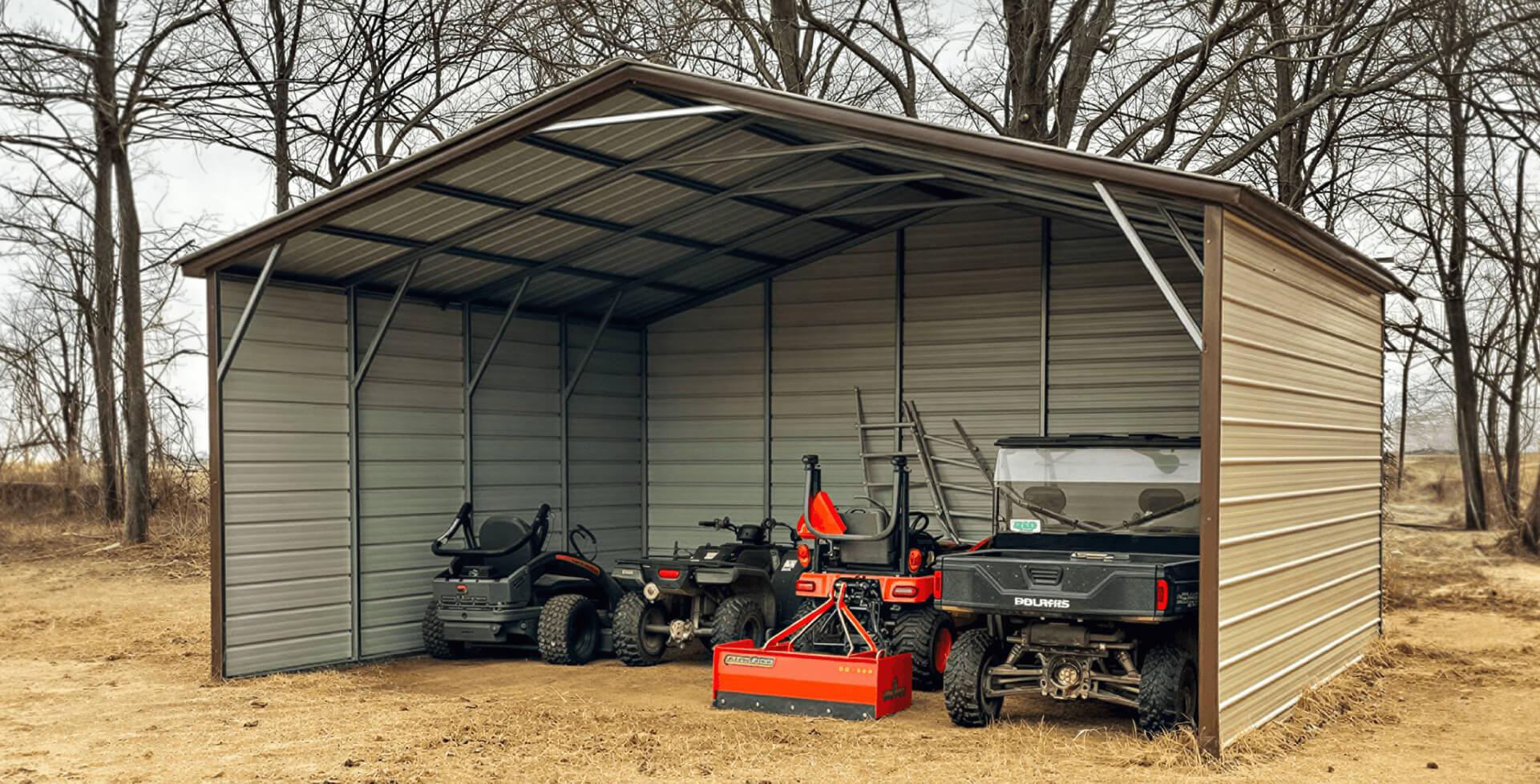 Open-sided metal shed with tan siding and a brown roof, housing several utility vehicles including ATVs and a compact tractor attachment.