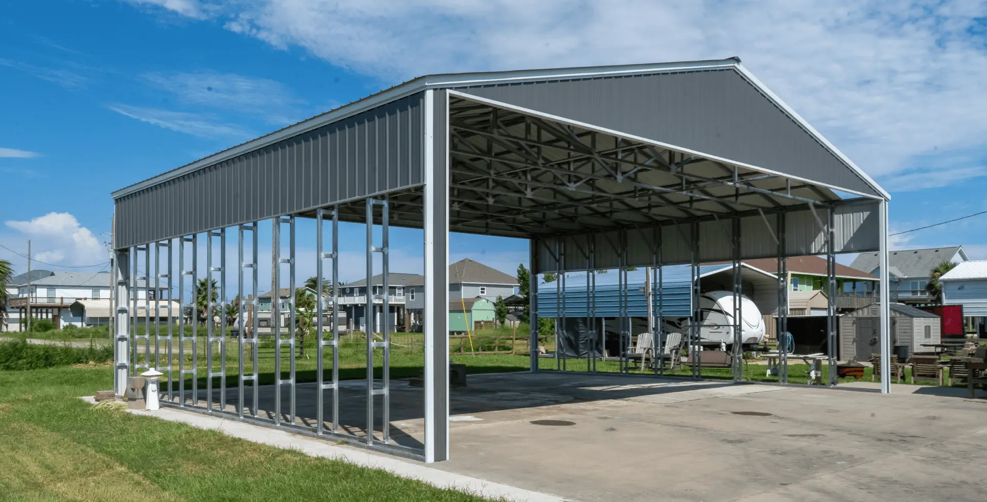 Large open metal building with galvanized steel frame anchored to a concrete slab, illustrating the durability and structural strength of steel buildings for storage or workshops.