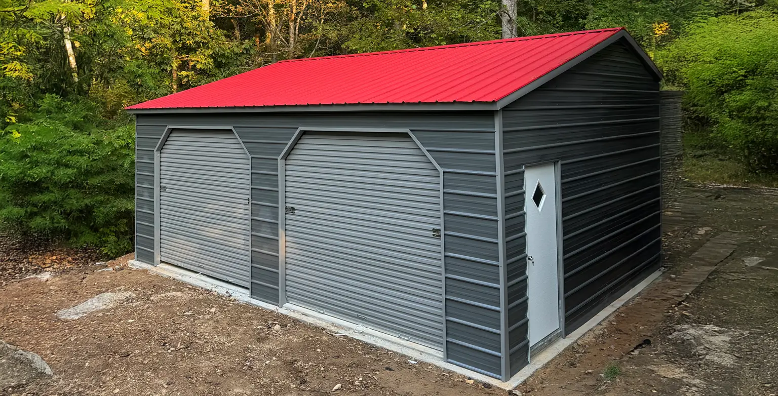 Large metal concession stand building with vertical roof panels and dual roll-up doors installed on a concrete slab foundation.