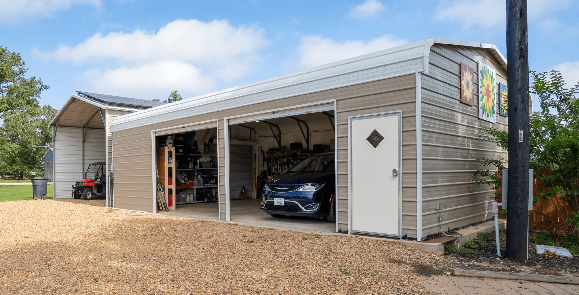 Prefab metal garage with open bays and a vehicle parked inside, showing a steel structure designed for vehicle storage and workshop space.