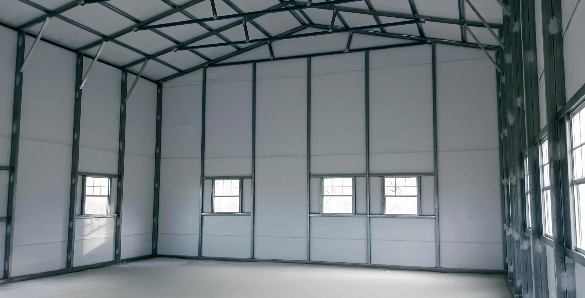 Interior view of a prefab steel garage showing metal framing and open space, highlighting durability and efficient construction design.