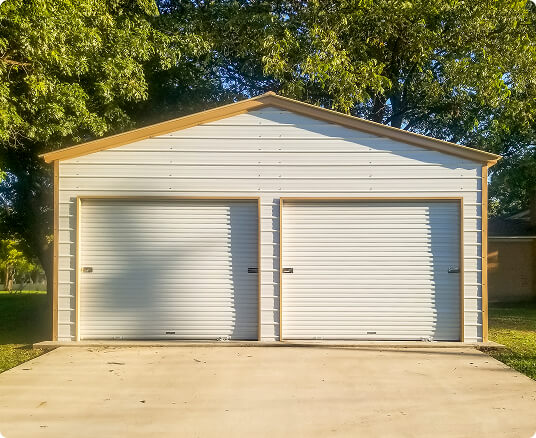 White two-car metal garage with steel siding, two roll-up doors, and a concrete driveway.