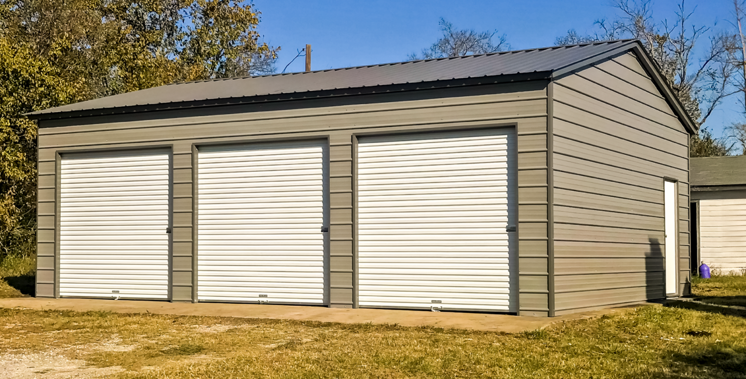 Compact gray metal warehouse-style building with three front roll-up doors and a side personnel door, illustrating a customizable steel storage solution designed for commercial use, organized access, and durable long-term equipment or inventory storage.