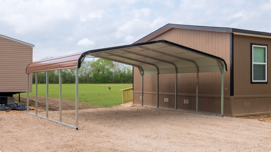 Freestanding mobile home carport next to a garage and driveway.