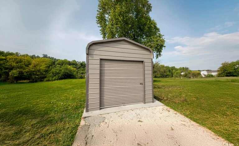 Metal garage in grassy landscape.
