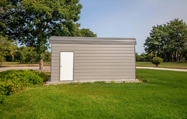 Metal garage in grassy area.