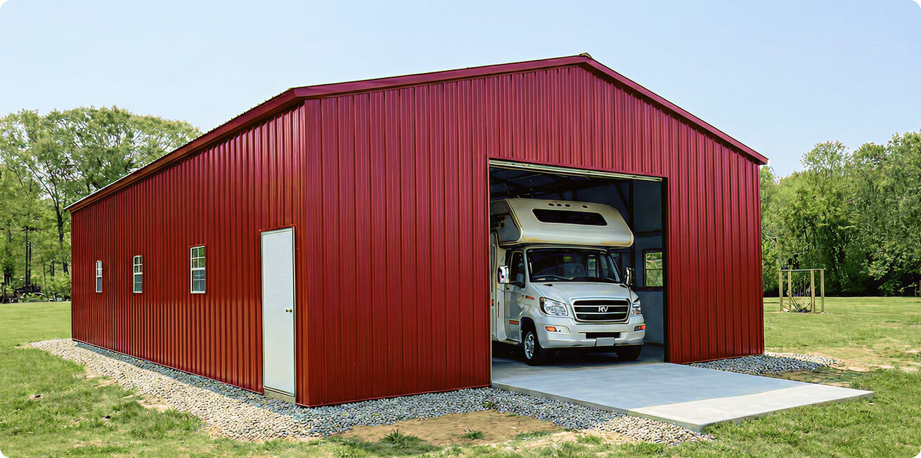 Red vertical metal RV garage with large open roll-up door and side entry door, featuring a white camper stored inside on a concrete slab, ideal for motorhome storage and weather protection.